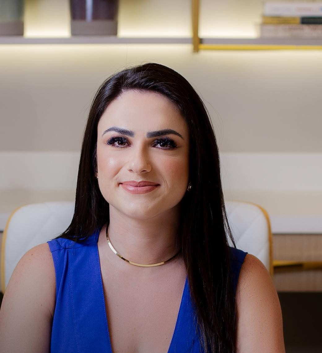 Dra. Gabrielle Valério no consultório, de blusa azul